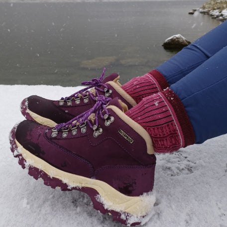 Collection of high-performance hiking boots displayed in an outdoor setting.